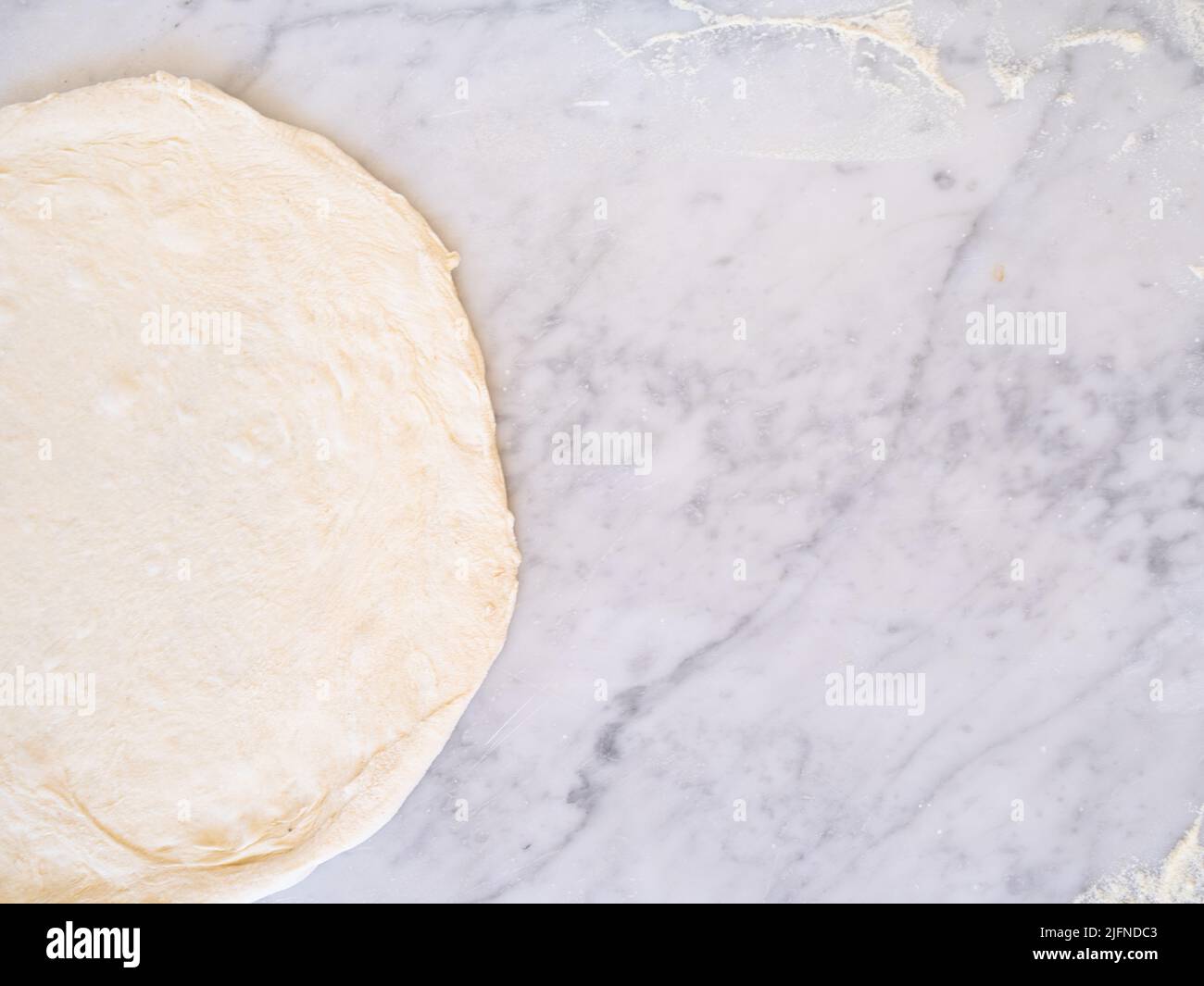 Foto des traditionellen weißen Pizzateigs mit Platz zum Kopieren auf einer Marmorplatte Stockfoto