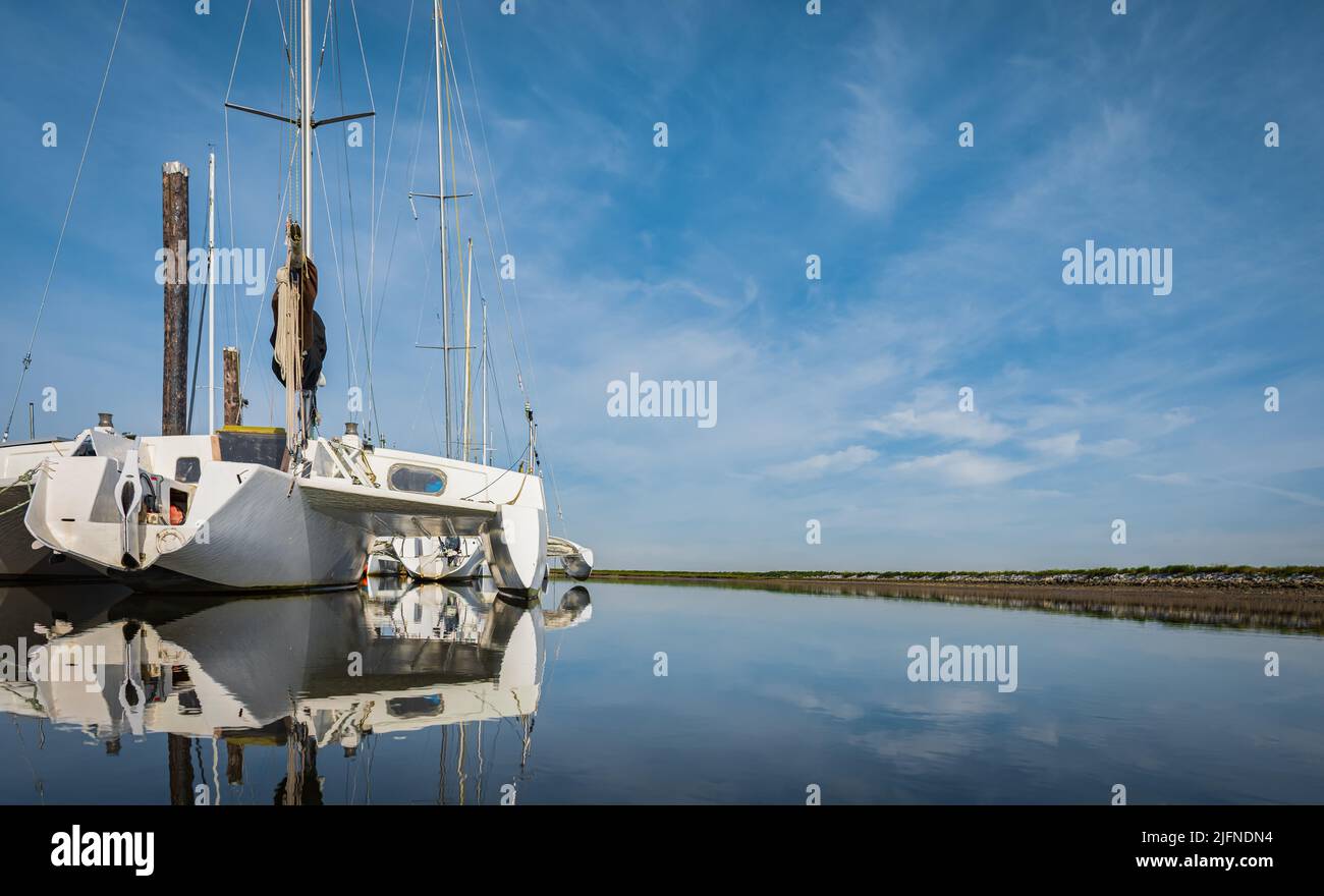 Wunderschöne Meereslandschaft und Segel-Katamaran am blauen Himmel im Hintergrund. Segeln auf dem Trimaran Sail Boat. Reisefoto, niemand, Platz für Text kopieren, Stockfoto