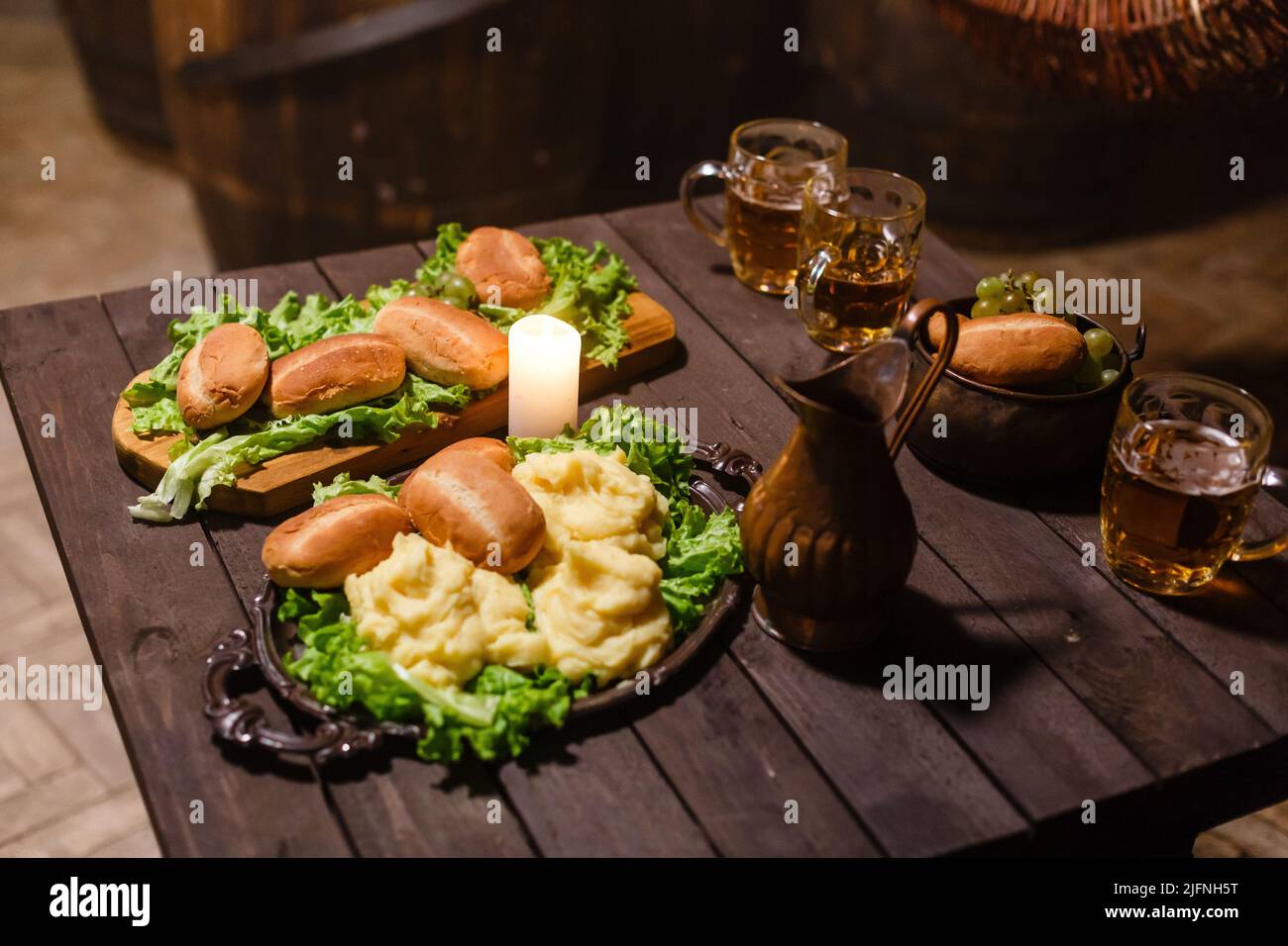 Laternen auf dem Tisch mit Bier. Kerzenständer und Bier auf einem alten Holztisch. Stockfoto