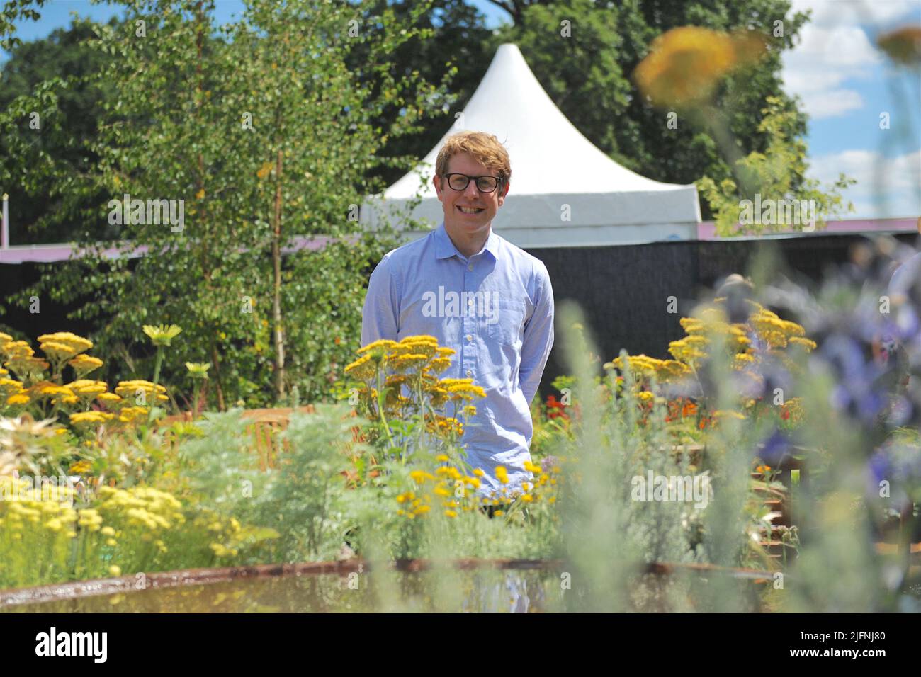 Hampton Court Palace, Surrey, Großbritannien - 04.06.2022, Josh Widdicombe (Komiker und Moderator) am Eröffnungstag des RHS Hampton Court Palace Garden Festivals. Die seit 1993 stattfindende Messe ist die prestigeträchtigste Blumen- und Gartenveranstaltung im Vereinigten Königreich und die größte jährliche Blumenschau der Welt. Die Planung und Organisation der Show dauert 18 Monate und bietet eine vielseitige Mischung aus wunderschönen Gärten, Blumenzelten und Pavillons, verteilt auf 34 Hektar, auf beiden Seiten des dramatischen langen Wassersees. Stockfoto