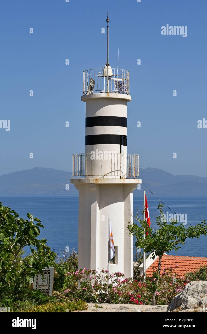 Kusadasi, Türkei - Juni Mai 2022: Besucher, die am historischen Leuchtturm auf Pigeon Island im Hafen von Kusadasi vorbeilaufen. Stockfoto