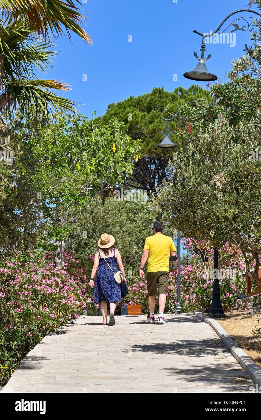 Kusadasi, Türkei - Juni 2022: Besucher, die am Leuchtturm auf der Pigeon Island im Hafen von Kusadasi vorbeilaufen. Stockfoto