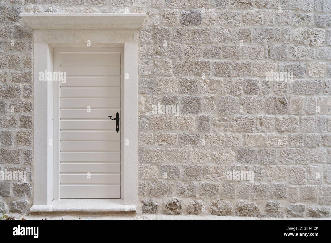 Eingang weiße Tür an der Steinmauer des Hauses. Stockfoto