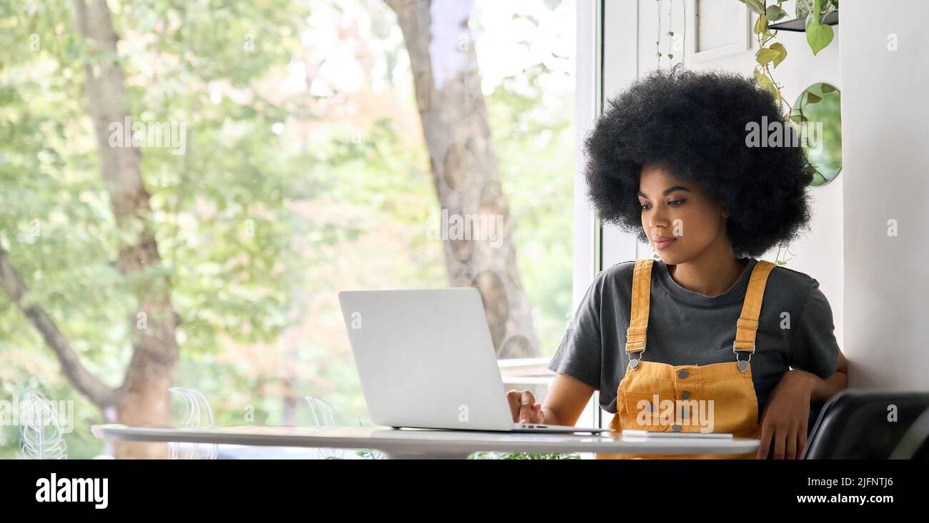 Glückliche junge Frau, die online lernt, Telearbeit im Büro. Stockfoto