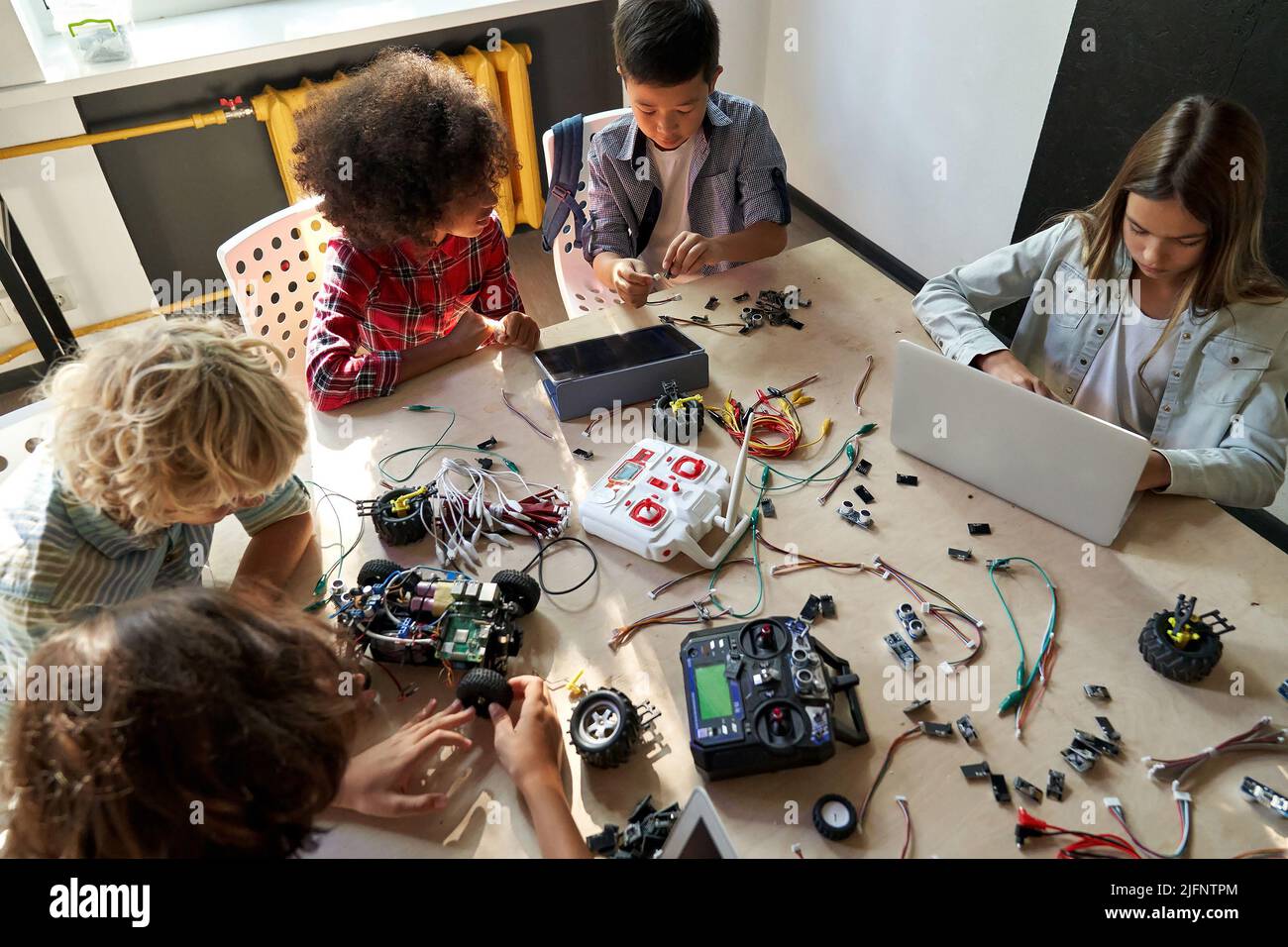 Gruppe von multirassischen Schulkindern am STEM-Klasse-Bauroboter. Tabellenansicht von oben. Stockfoto