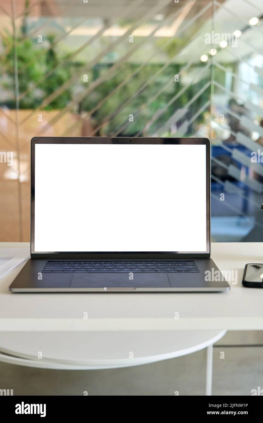 Arbeitsplatz im modernen Büro mit weißem leerem PC-Laptop-Computer mit aufgearbeittem Bildschirm. Stockfoto