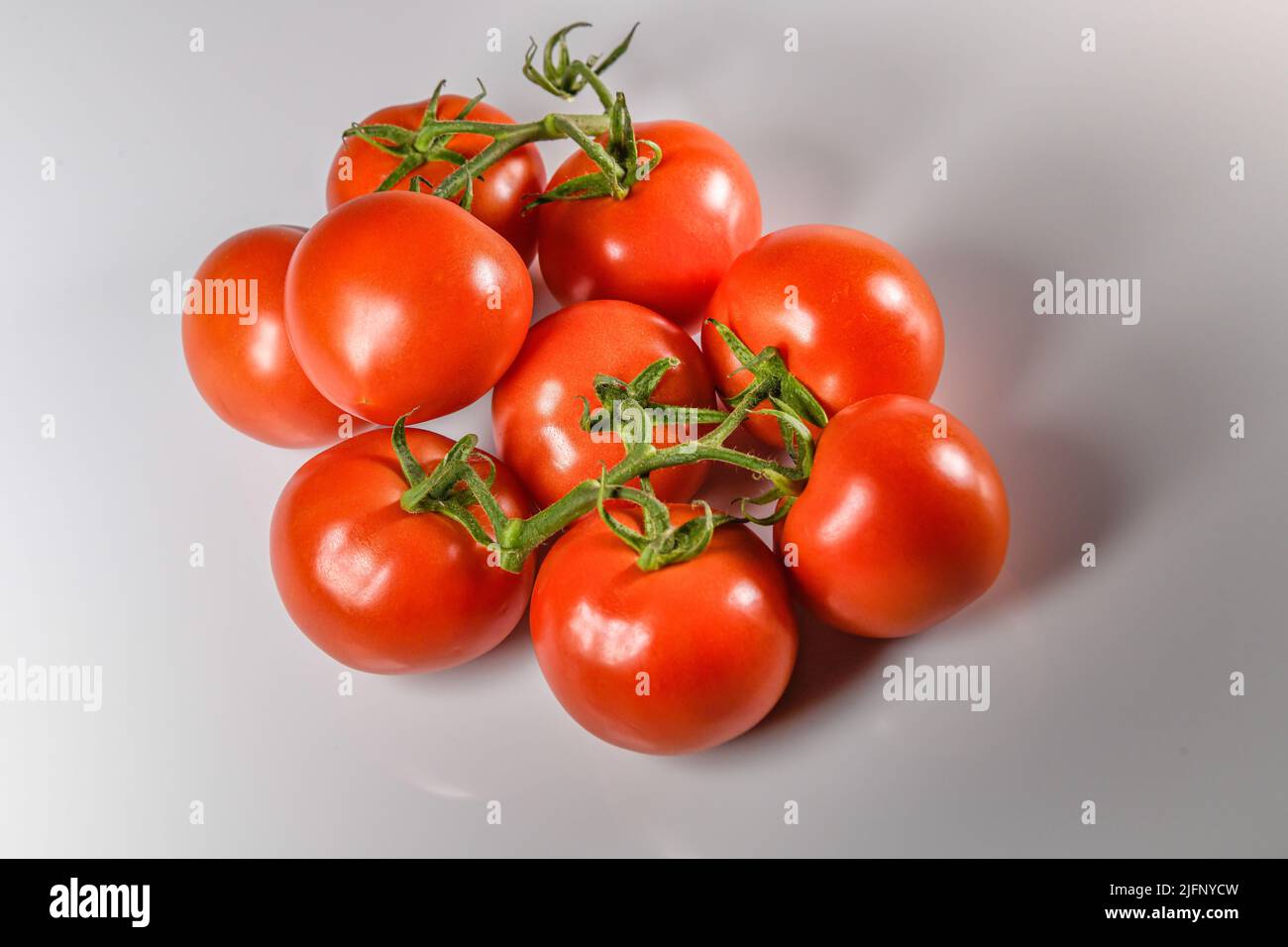 Tomaten Ausschneiden von Tomaten auf Weinstock - rot reife Tomaten - Tomaten weißen Hintergrund Ausschnitttomatos Solanum lycopersicum Stockfoto