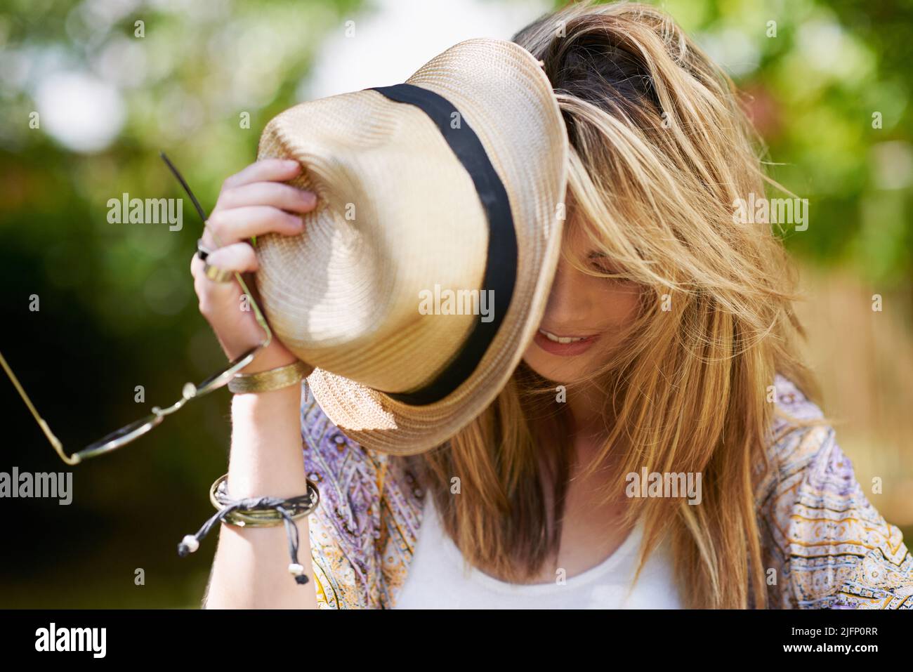 Schnappen Sie sich Ihren Hut, los geht's in den Sommerurlaub. Aufnahme einer jungen trendigen Frau, die einen Tag in der Natur genießt. Stockfoto