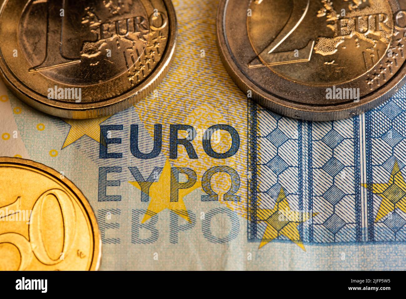 Euro-Banknote mit Münzen. Nahaufnahme des EURO-Schreibens über Geld. 20-Euro-Schein mit zwei und einer Euro-Münze. 50 Cent Münze. Stockfoto