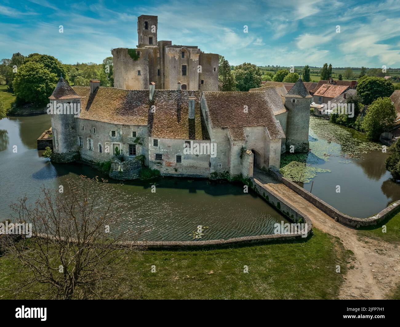 Luftaufnahme des Schlosses Sagonne in Frankreich mit innerem Komplex, umgeben von einer Außenwand, verstärkt durch kreisförmige Türme, mit Wasser gefüllter Graben Stockfoto