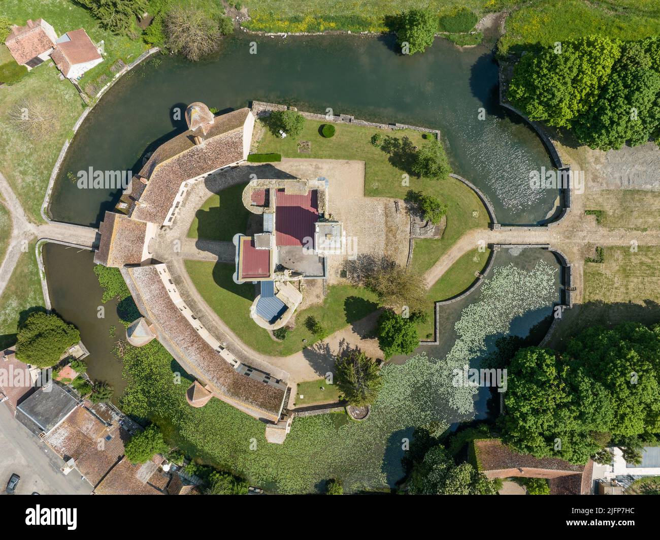 Luftaufnahme des Schlosses Sagonne in Frankreich mit innerem Komplex, umgeben von einer Außenwand, verstärkt durch kreisförmige Türme, mit Wasser gefüllter Graben Stockfoto