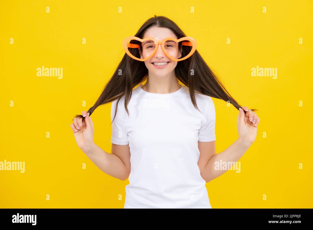 Porträt einer schönen Frau mit lustigen Gläsern. Feiern und feiern. Mädchen mit Spaß, Porträt auf gelbem Hintergrund. Stockfoto
