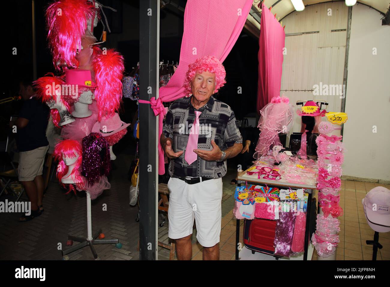 4. Juli 2022, Bellaria Igea Marina, Rimini, Italien: Bellaria Igea Marina, Rimini, Italien - 02. Juli 2022 :ein Verkäufer von Perücken und rosa Haaren vor ihrem Geschäft zu sehen, besuchen den Karneval in Rosa während der Pink Night Event.die rosa Nacht ist der Silvester des Sommers, Das wichtigste Ereignis des italienischen Sommers an der Riviera. Alles ist mit Rosa getönt und Sie können das Gefühl der Feier, die von Ravenna bis Cattolica explodiert in Shows und Konzerten auf nationaler und internationaler Ebene schmecken.die Rose ist eine Farbe, die die Süße, Freundlichkeit und Gastfreundschaft, die die Werte, die die erinnern ruft Stockfoto