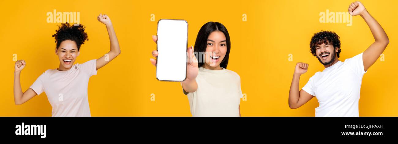 Panoramafoto von drei multirassischen Menschen auf isoliertem orangefarbenem Hintergrund. Asiatisches Mädchen zeigt Smartphone mit weißem Mockup-Bildschirm, indischen Kerl und afroamerikanischen Mädchen feiern Erfolg, Lächeln Stockfoto