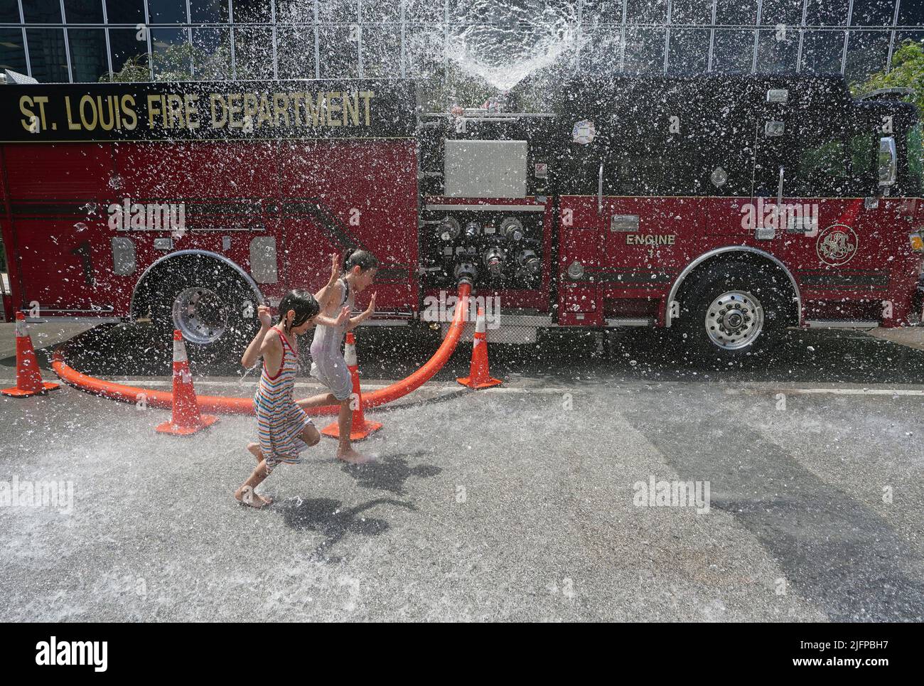 St. Louis, Usa. 04.. Juli 2022. Kinder versuchen, die 98 Grad Hitze zu schlagen, indem sie am 2. Tag der Messe St. Louis in St. Louis am Montag, dem 4. Juli 2022, durch einen Wasserspray der Feuerwehr St. Louis laufen. Foto von Bill Greenblatt/UPI Credit: UPI/Alamy Live News Stockfoto
