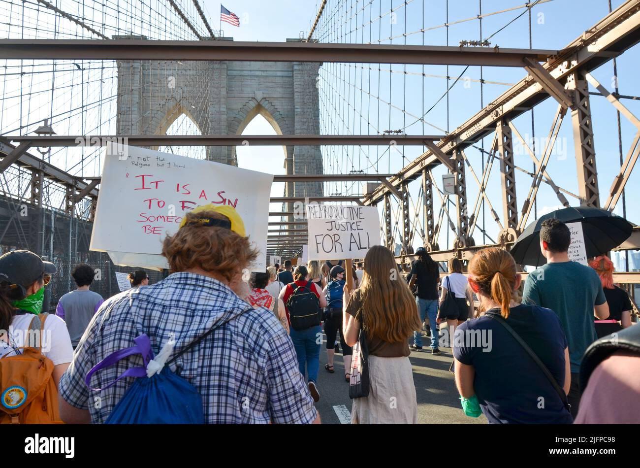 Hunderte halten am 4. Juli 2022 Zeichen, während sie über die Brooklyn Bridge, New York City, marschieren, um Gerechtigkeit für Abtreibung und andere soziale Probleme zu fordern. Stockfoto