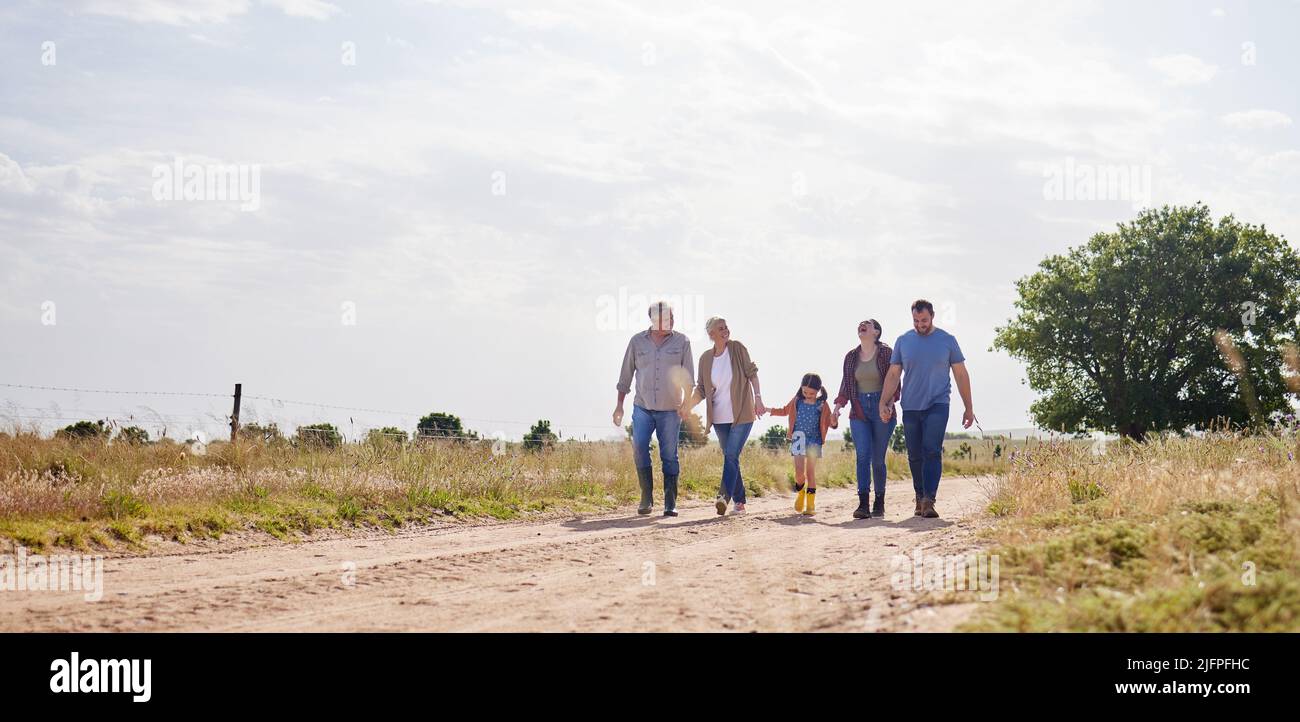 Hier arbeiten wir zusammen, spielen zusammen und haben ein gemeinsames Leben geschaffen. Aufnahme einer Familie mit mehreren Generationen, die auf einem Bauernhof zusammenläuft. Stockfoto