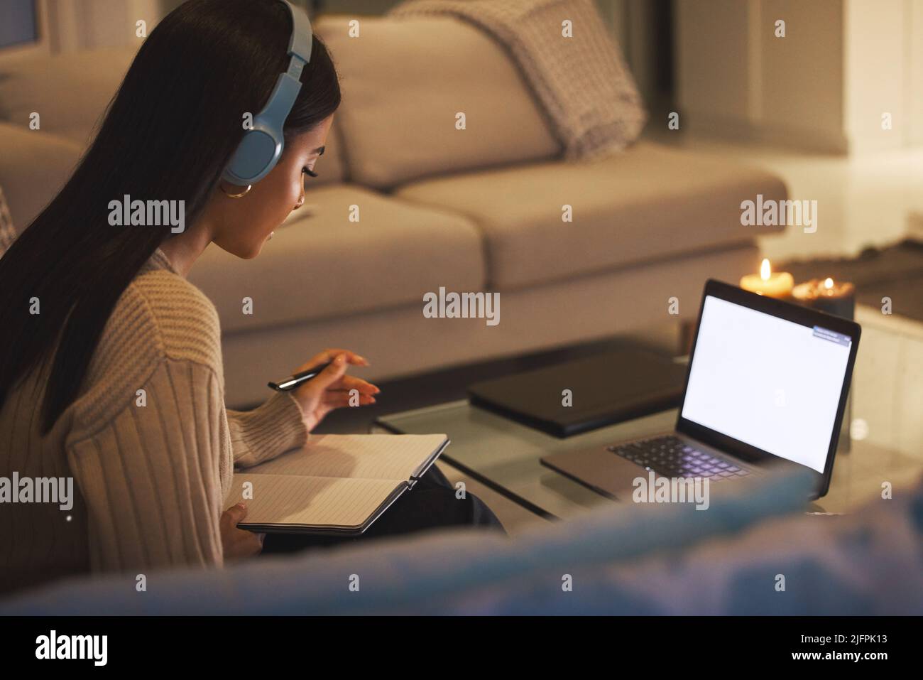 Die Arbeit vor den Prüfungen. Eine kurze Aufnahme einer attraktiven jungen Frau, die spät in der Nacht in ihrem Wohnzimmer zu Hause arbeitet. Stockfoto