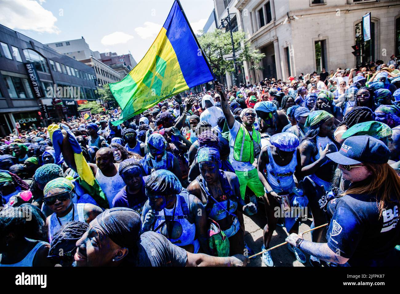 Montreal, Kanada. 02.. Juli 2022. Die Nachtschwärmer schwenken eine Flagge von St. Vincent und den Grenadinen, während sie dem Hauptauto folgen. Seit 1975 fand die Carifiesta in Montreal statt, um die karibische Kultur und Tradition mit einer farbenfrohen Parade zu feiern und zu ehren. Das jährliche Festival isnít wie die meisten Karnevals nach christlicher Tradition. itís wird während des kanadischen Sommers durchgeführt und itís geht alles um die Umarmung der Montrealís karibischen Gemeinschaft. Kredit: SOPA Images Limited/Alamy Live Nachrichten Stockfoto