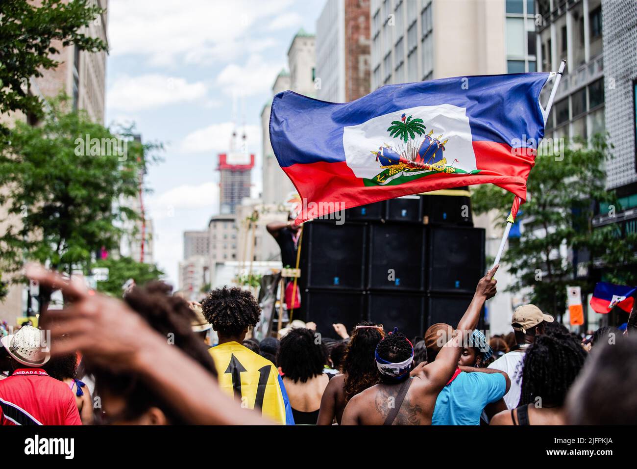 Montreal, Kanada. 02.. Juli 2022. Ein Nachtschwärmer sah während der Parade eine haitianische Flagge schwenken. Seit 1975 fand die Carifiesta in Montreal statt, um die karibische Kultur und Tradition mit einer farbenfrohen Parade zu feiern und zu ehren. Das jährliche Festival isnít wie die meisten Karnevals nach christlicher Tradition. itís wird während des kanadischen Sommers durchgeführt und itís geht alles um die Umarmung der Montrealís karibischen Gemeinschaft. (Foto: Giordanno Brumas/SOPA Images/Sipa USA) Quelle: SIPA USA/Alamy Live News Stockfoto