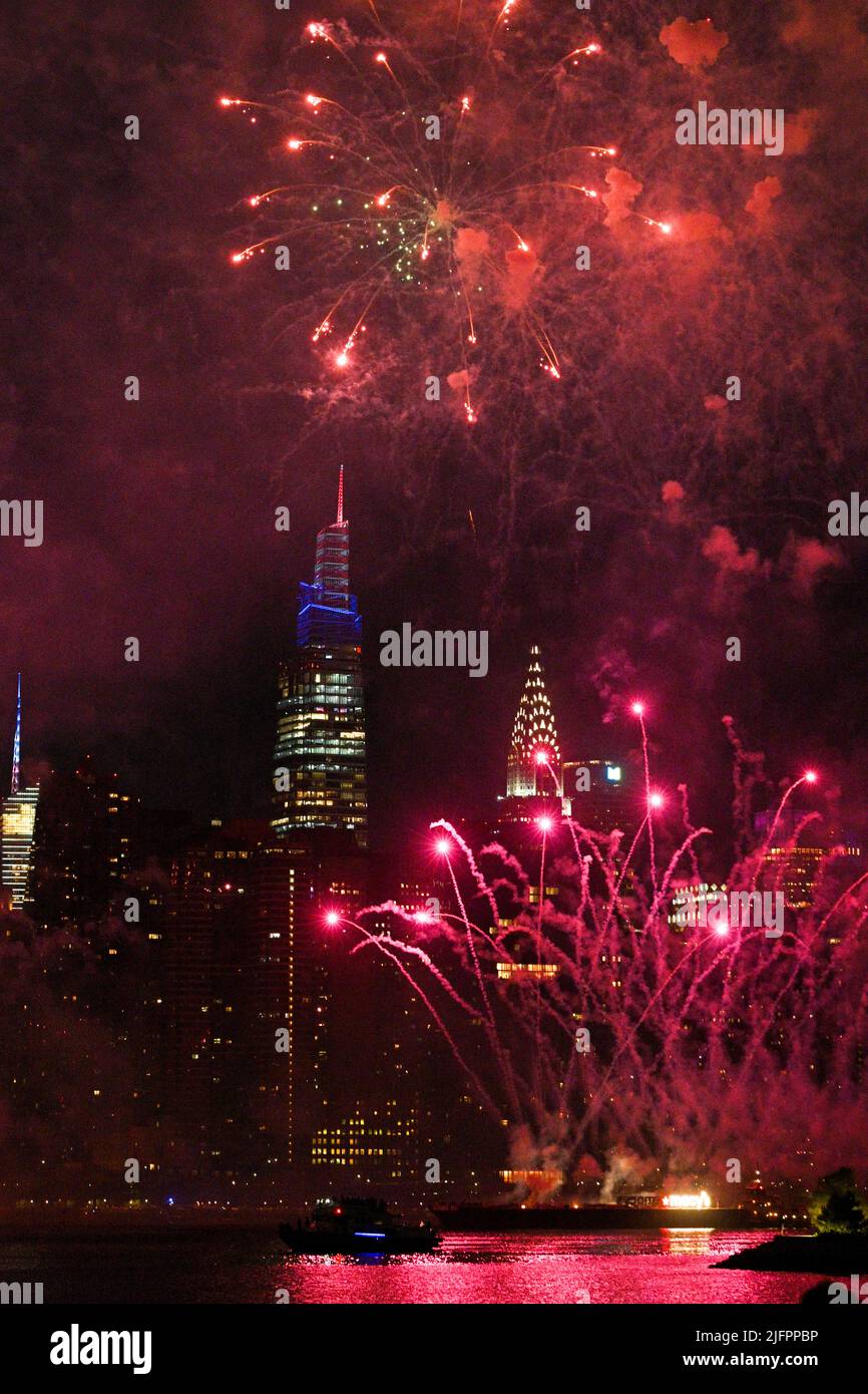 Das Feuerwerk des Macy am 4. Juli leuchtet den Himmel über Midtown Manhattan und dem Chrysler Building, vom Greenpoint Landing Espl aus gesehen Stockfoto