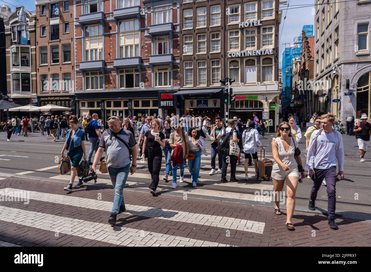 Amsterdam, Niederlande - 21. Juni 2022: Viele Menschen überqueren die Straße in Amsterdam Stockfoto