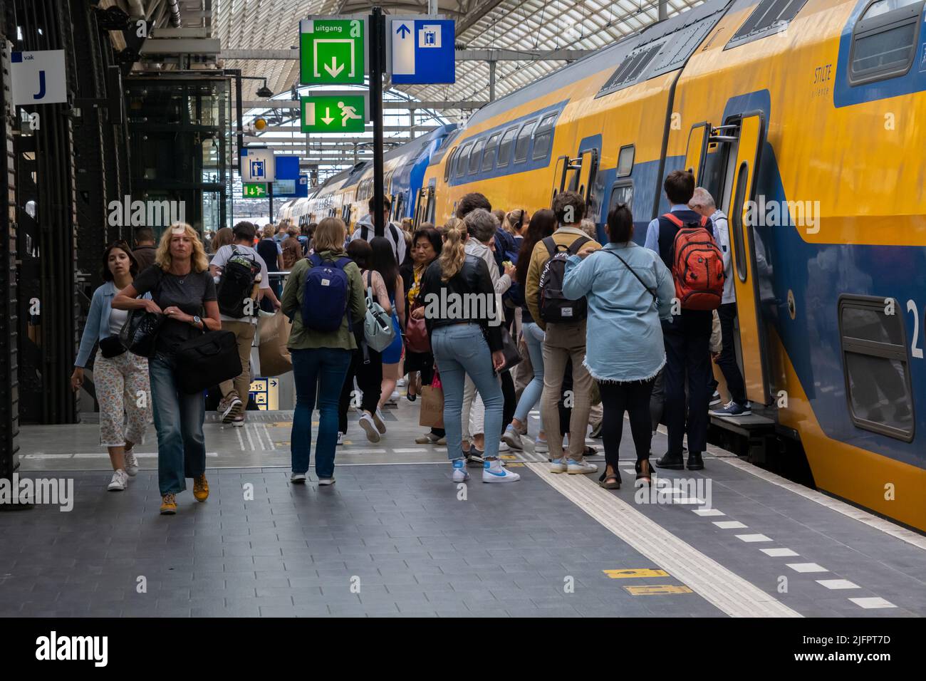 Amsterdam, Niederlande - 21. Juni 2022: Menschen steigen in den Nederlandse Spoorwegen-Zug im Amsterdamer Hauptbahnhof ein Stockfoto