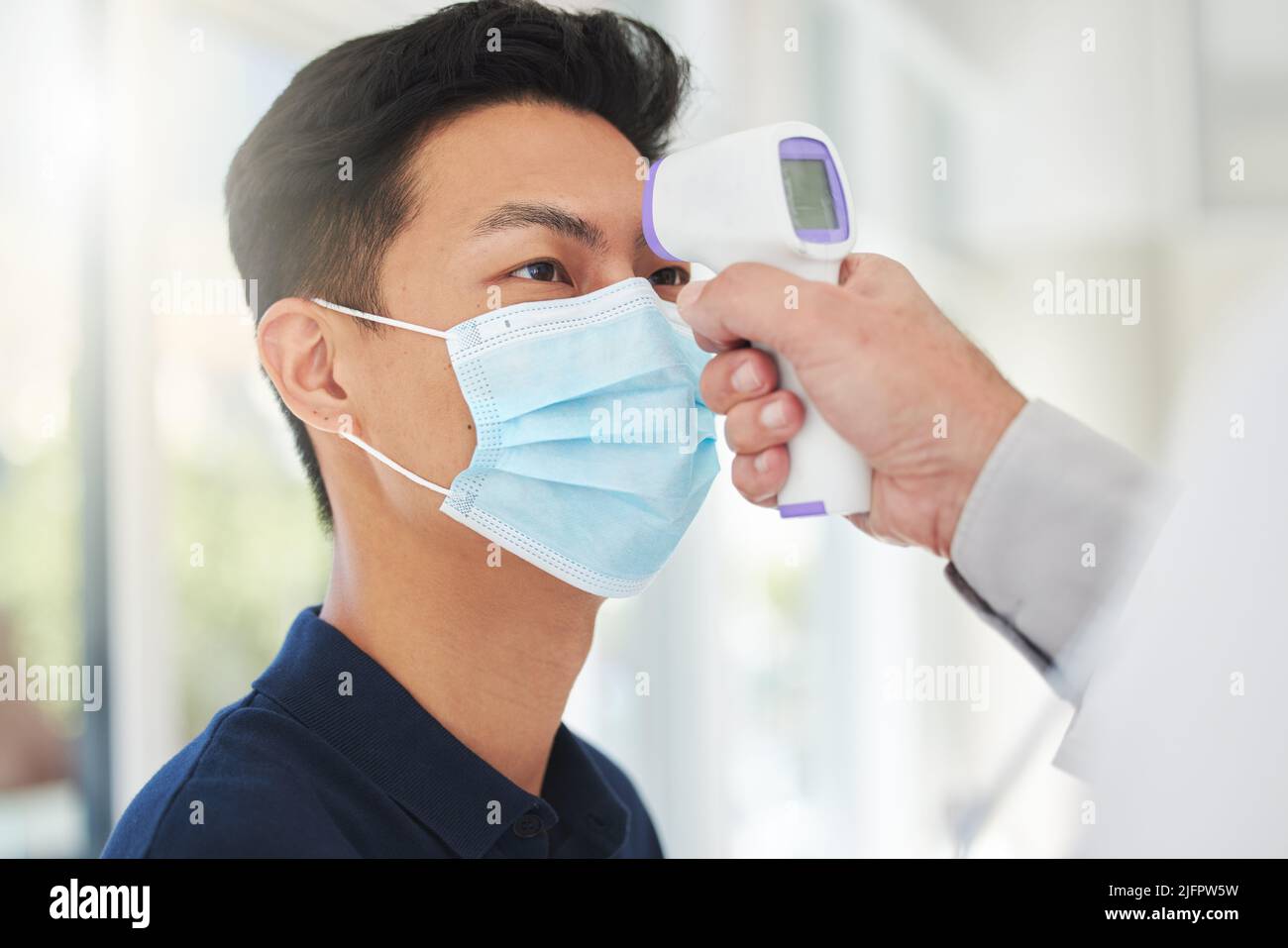Überwachen Sie Ihre Temperatur, um sicher zu sein. Aufnahme eines nicht erkennbaren Arztes, der die Temperatur eines Patienten in einem Krankenhaus einnahm. Stockfoto