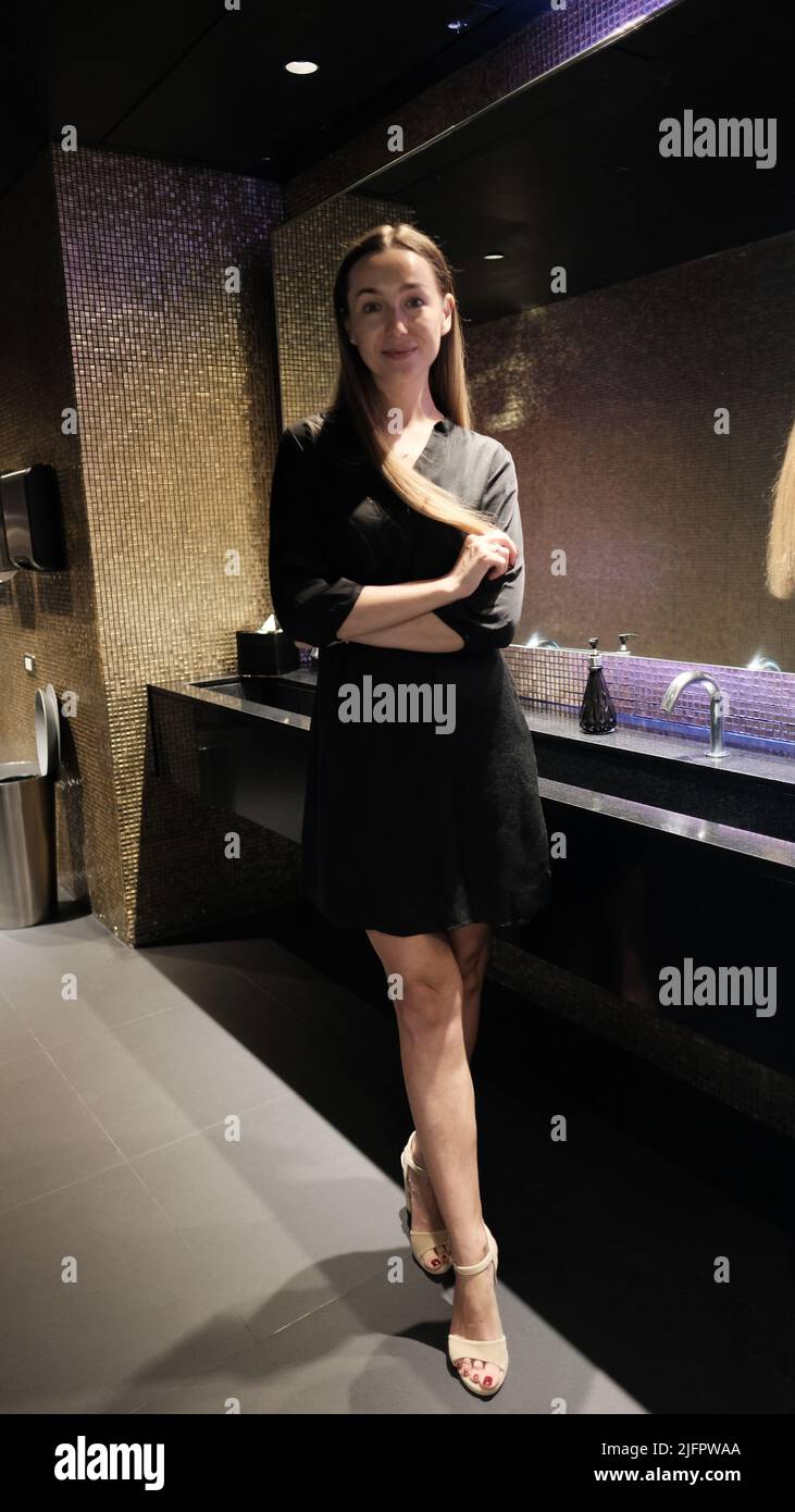 Waschraum Attraktive, knallige Dame mit langen, brünetten Haaren im Lounge Bar Cafe Restaurant Stockfoto
