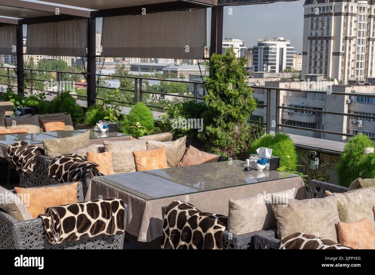 Dachbar mit Blick auf den herrlichen blauen Himmel der Stadt. Café auf dem Dach des Gebäudes. Tisch auf dem Dach Restaurant mit Blick auf die Megapolis. b Stockfoto