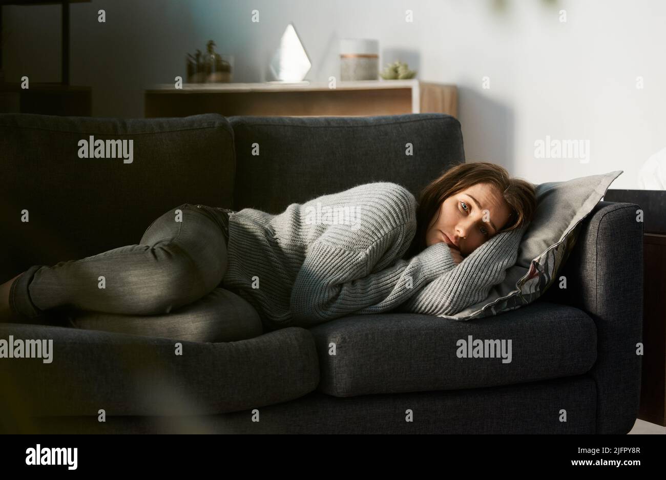Ich bin heute nicht in Bewegung. Aufnahme einer jungen Frau, die sich deprimiert auf ihrer Couch liegend fühlte. Stockfoto