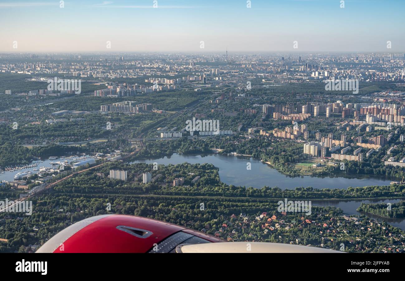 Luftaufnahmen einer großen Stadt aus einem Flugzeugfenster. Blick auf die moderne Stadt vom Flugzeugfenster aus Stockfoto