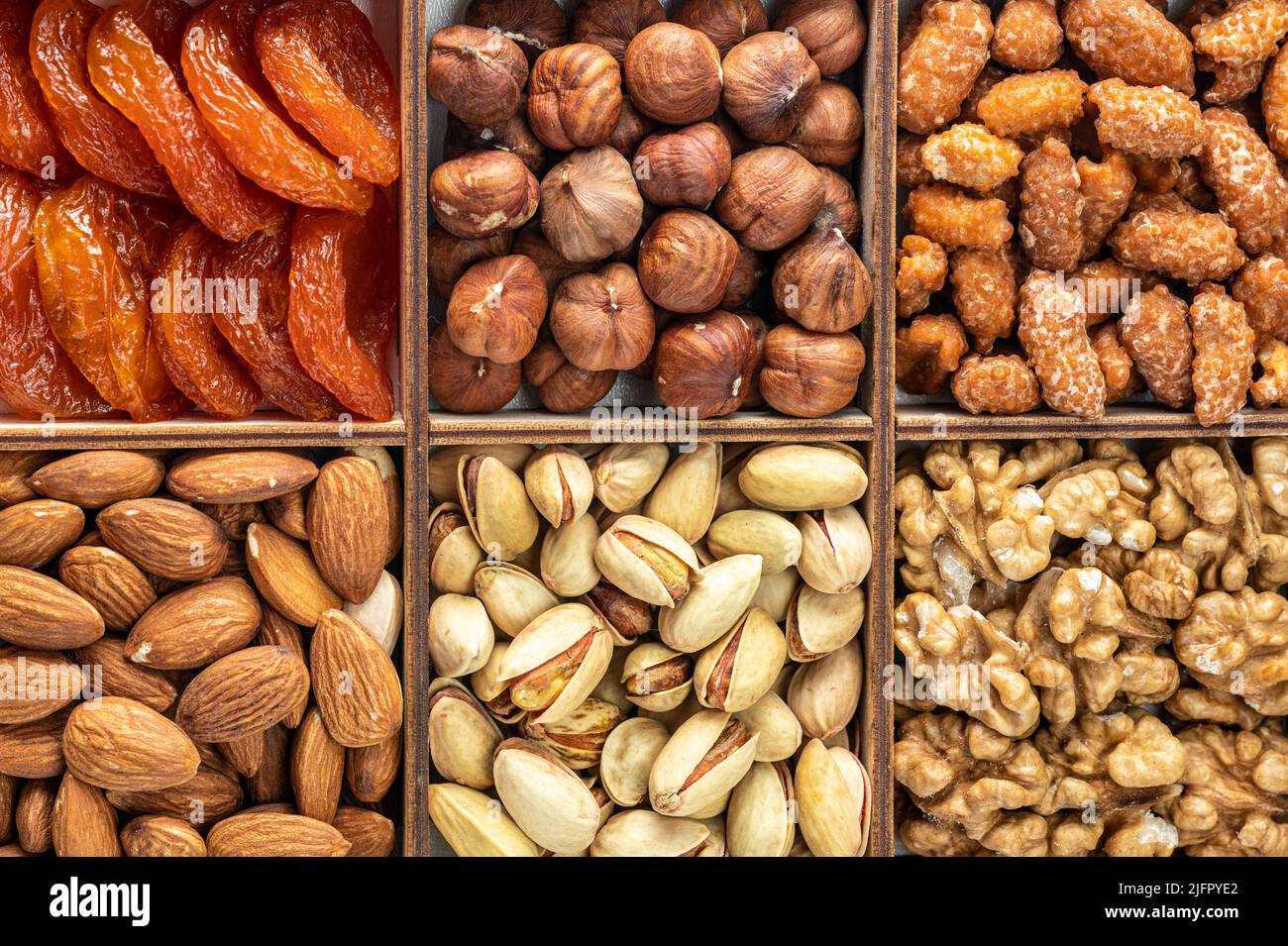 Verschiedene kandierte Beeren, getrocknete Früchte, Nüsse und Samen, Draufsicht. Organische Mischnüsse Hintergrund. Gesunde Ernährung, nützliche Mikroelemente und Vitamine. Usef Stockfoto