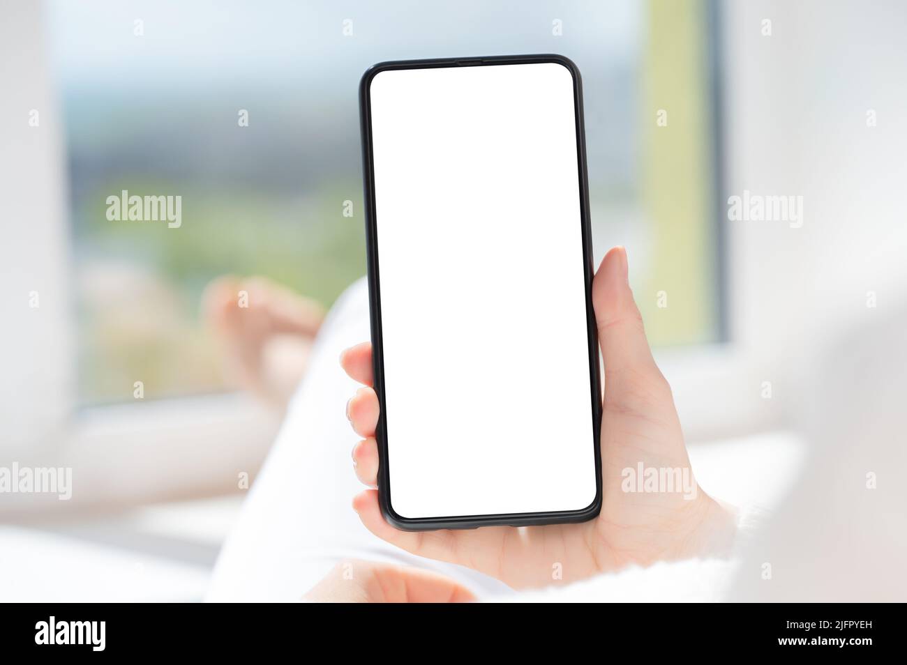 Eine Kundin hält ein Handymockup mit weißem Bildschirm in der Hand. Nutzen Sie die mobile Shopping-App, lesen Sie Social-Media-Nachrichten, senden Sie SMS, um Essen zu bestellen Stockfoto