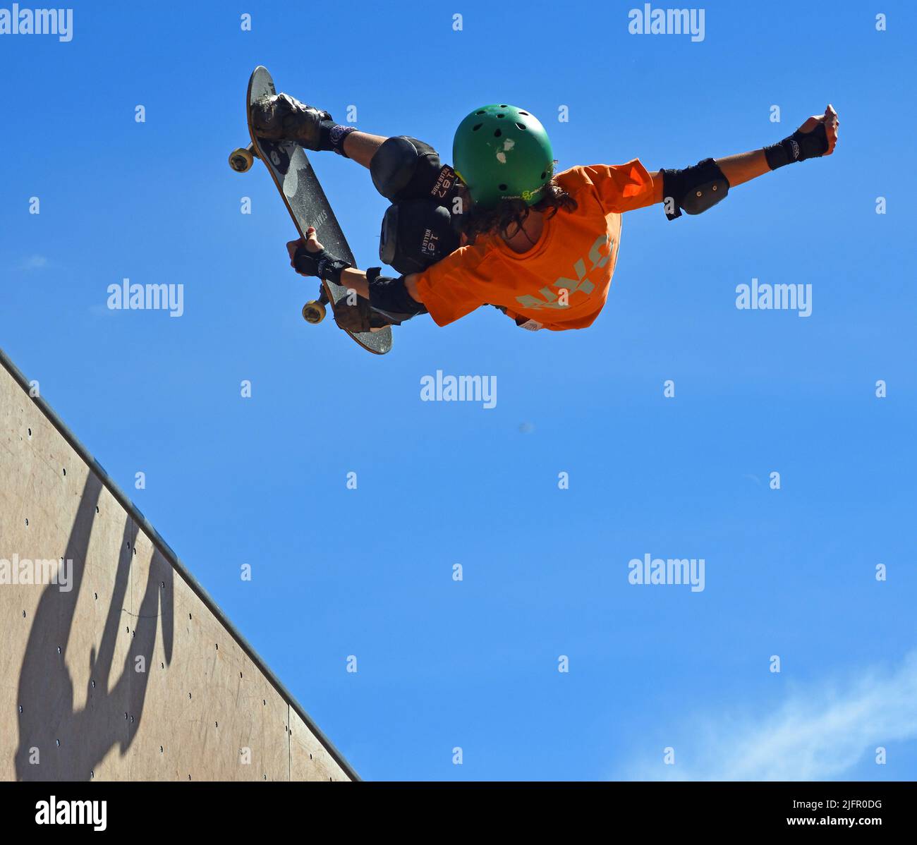Skateboarder beim Halb-Stunt auf der Vert-Rampe. Stockfoto