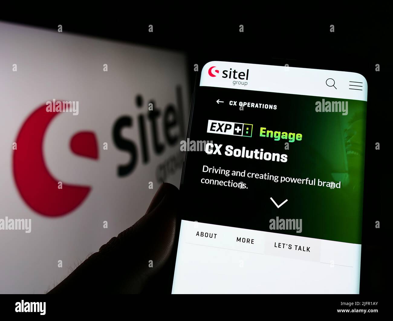 Person, die Smartphone mit der Webseite des US-Contact Center-Unternehmens Sitel Group auf dem Bildschirm vor dem Logo hält. Konzentrieren Sie sich auf die Mitte des Telefondisplays. Stockfoto