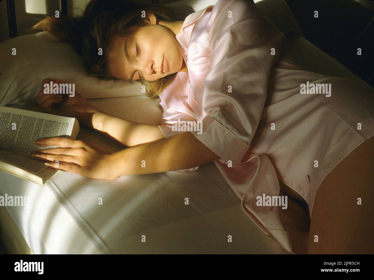 Ziemlich blonde Mädchen Schlafzimmer mit Buch schlafen Stockfoto