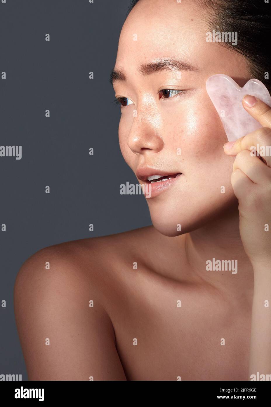 Bestimmte Trends sind einen Sprung wert. Studioaufnahme einer schönen jungen Frau mit einem Kratzwerkzeug auf ihrem Gesicht. Stockfoto