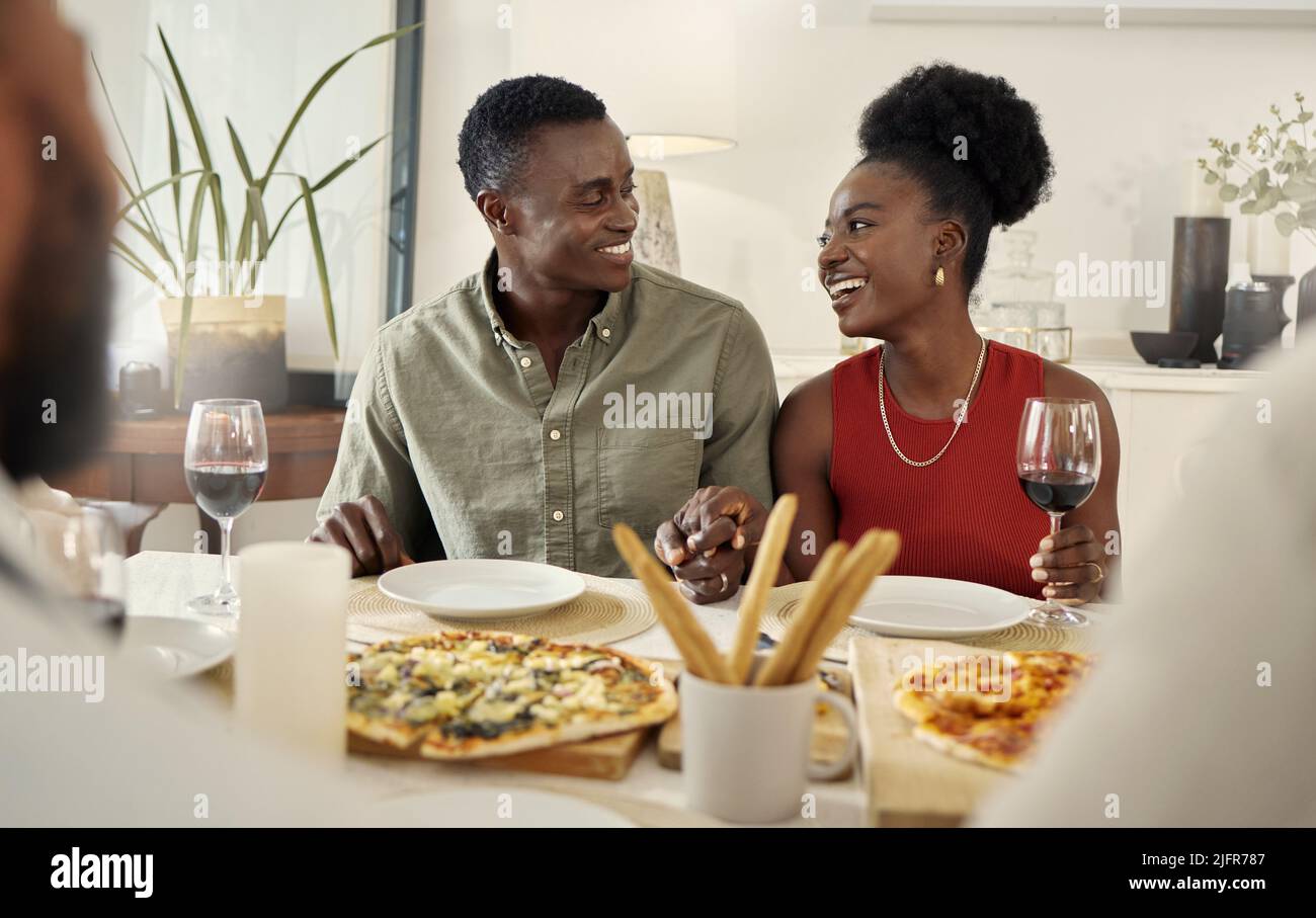 Mit unseren Pizzadaten halten wir es stilvoll. Aufnahme eines liebevollen Paares, das zusammen an einem Esstisch sitzt. Stockfoto