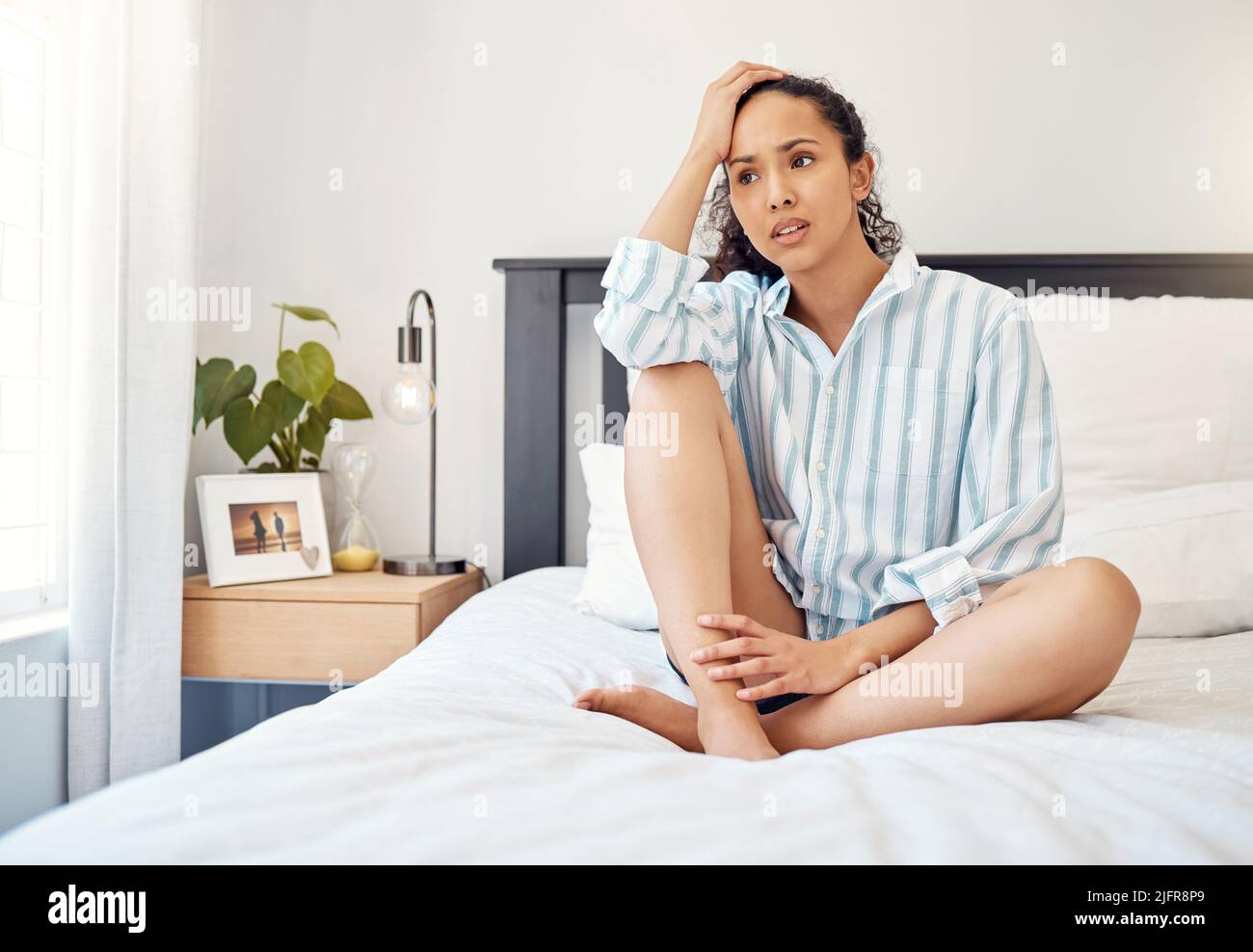 Lassen Sie sich nicht von Ihren Gedanken kontrollieren. Aufnahme einer jungen Frau, die besorgt aussieht, während sie auf ihrem Bett bei Homer sitzt. Stockfoto