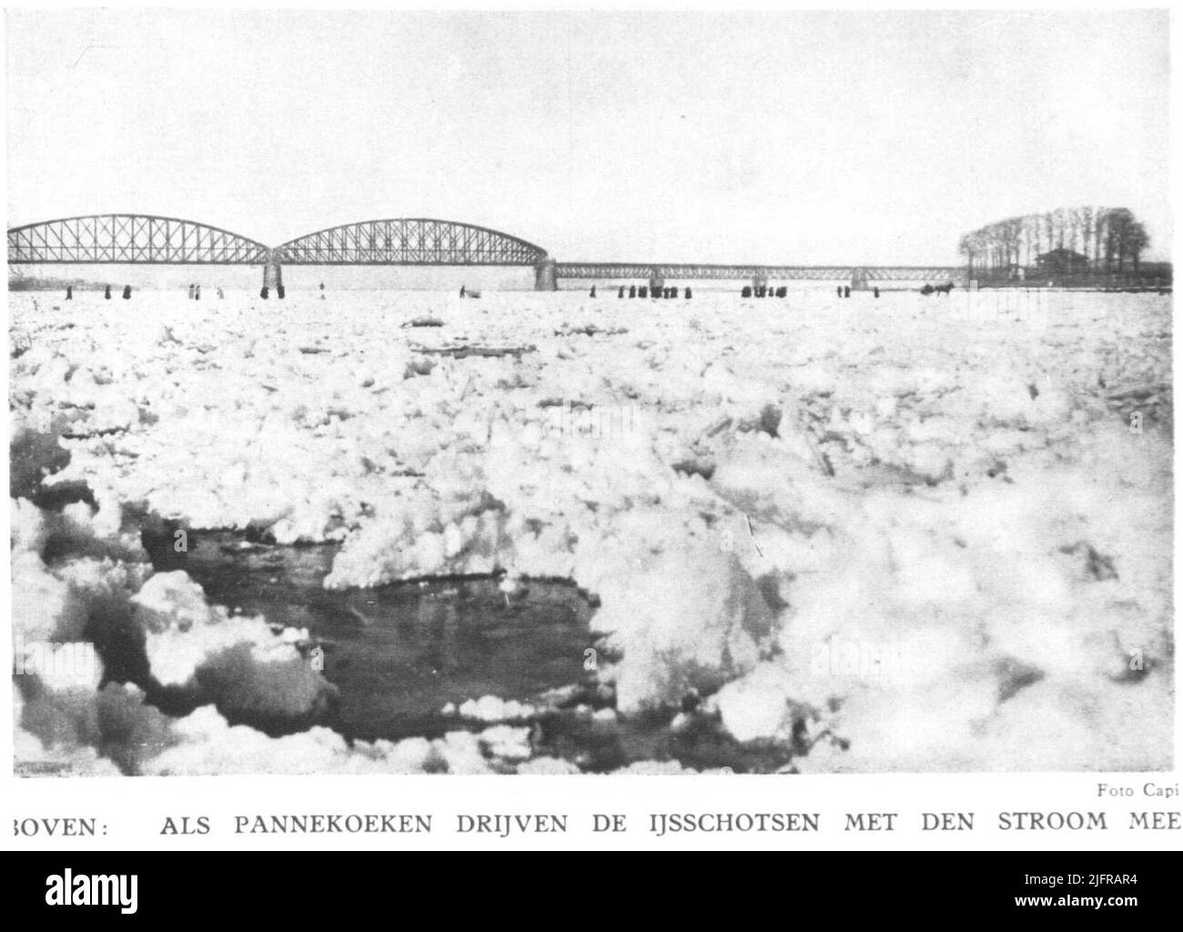 Der gefrorene Fluss De Waal mit Eisschollen, im Hintergrund die Eisenbahnbrücke. Stockfoto