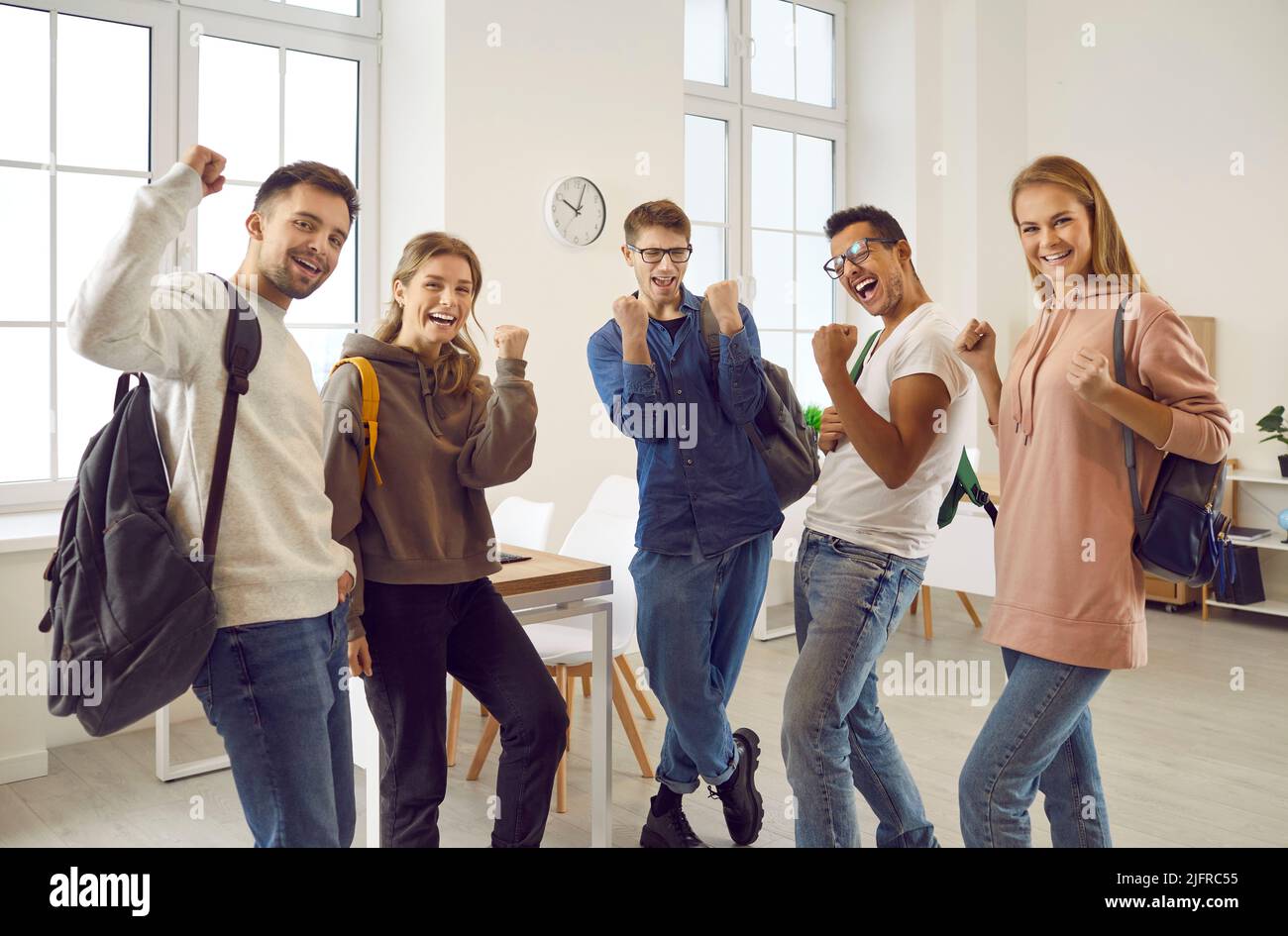 Eine Gruppe glücklicher, vielfältiger Universitätsstudenten, die mit der Faust pumpten und jauchzten Ja Stockfoto