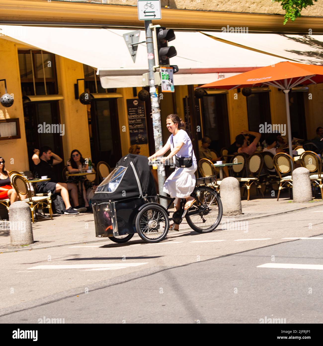 München, Deutschland-30. Juni 2022:Eine Frau fährt mit Kindern auf einem modifizierten Lastenrad. Stockfoto