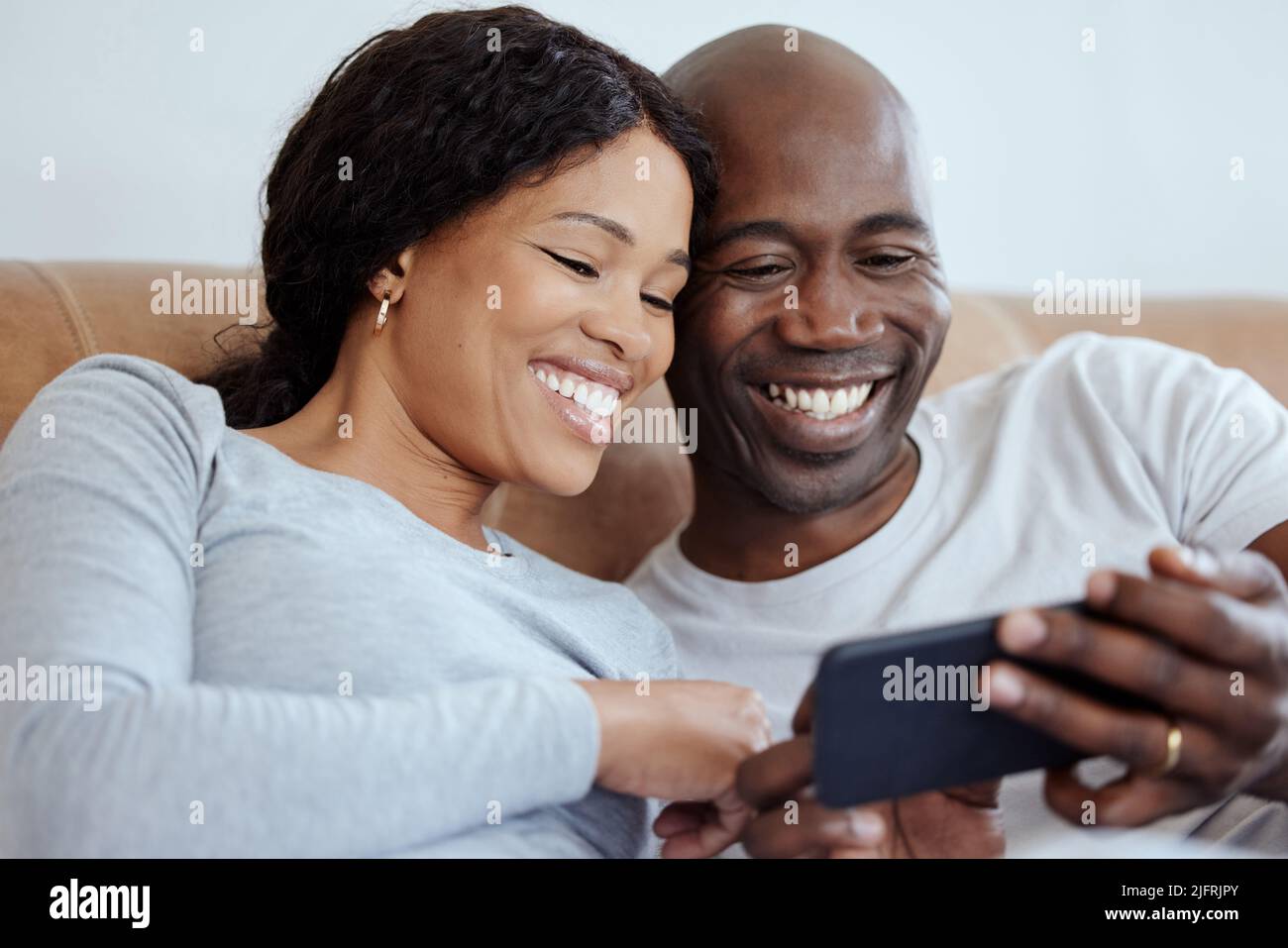 Familie bedeutet, dass niemand zurückgelassen oder vergessen wird. Aufnahme eines jungen Paares mit einem Smartphone im Bett zu Hause. Stockfoto