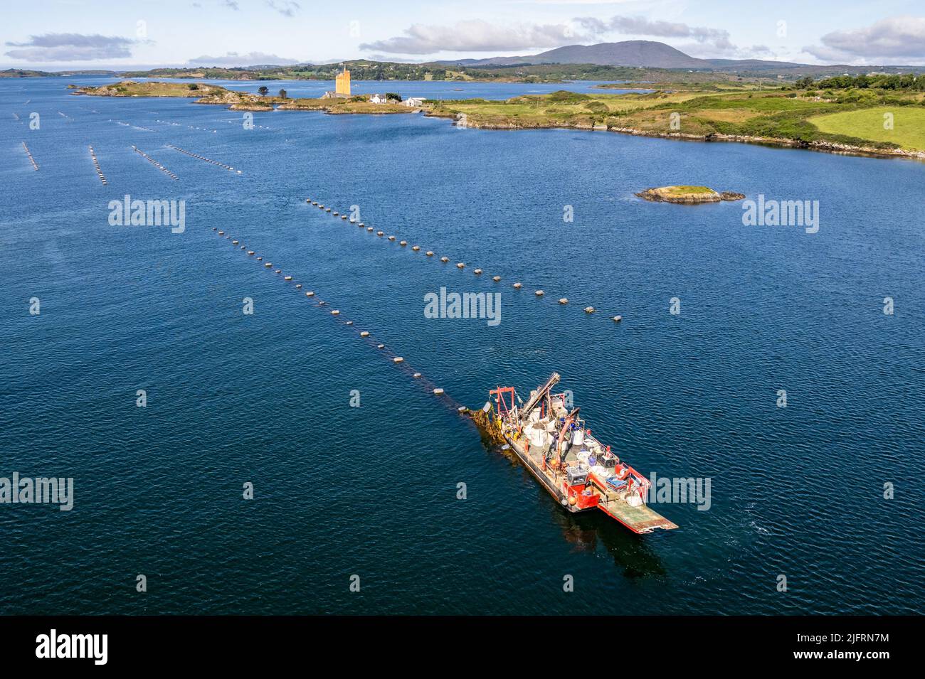 Roaring Water Bay, West Cork, Irland. 5.. Juli 2022. An einem schönen Sommertag in West Cork fischt das Fischerboot „Morning Light“ in der Roaring Water Bay nach Muscheln, während Jeremy Irons Zuhause „Kilcoe Castle“ im Hintergrund steht. Quelle: AG News/Alamy Live News Stockfoto