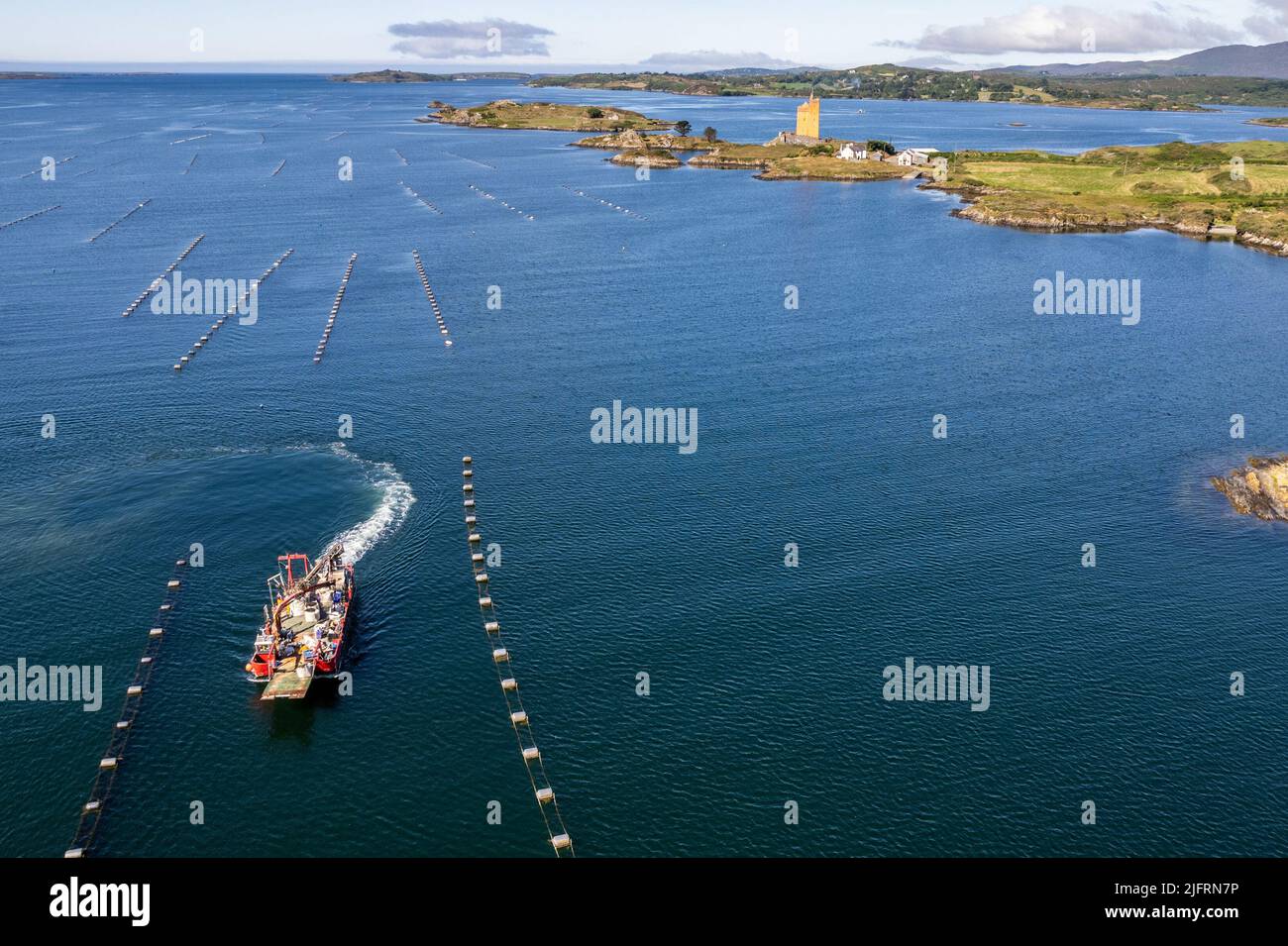 Roaring Water Bay, West Cork, Irland. 5.. Juli 2022. An einem schönen Sommertag in West Cork fischt das Fischerboot „Morning Light“ in der Roaring Water Bay nach Muscheln, während Jeremy Irons Zuhause „Kilcoe Castle“ im Hintergrund steht. Quelle: AG News/Alamy Live News Stockfoto