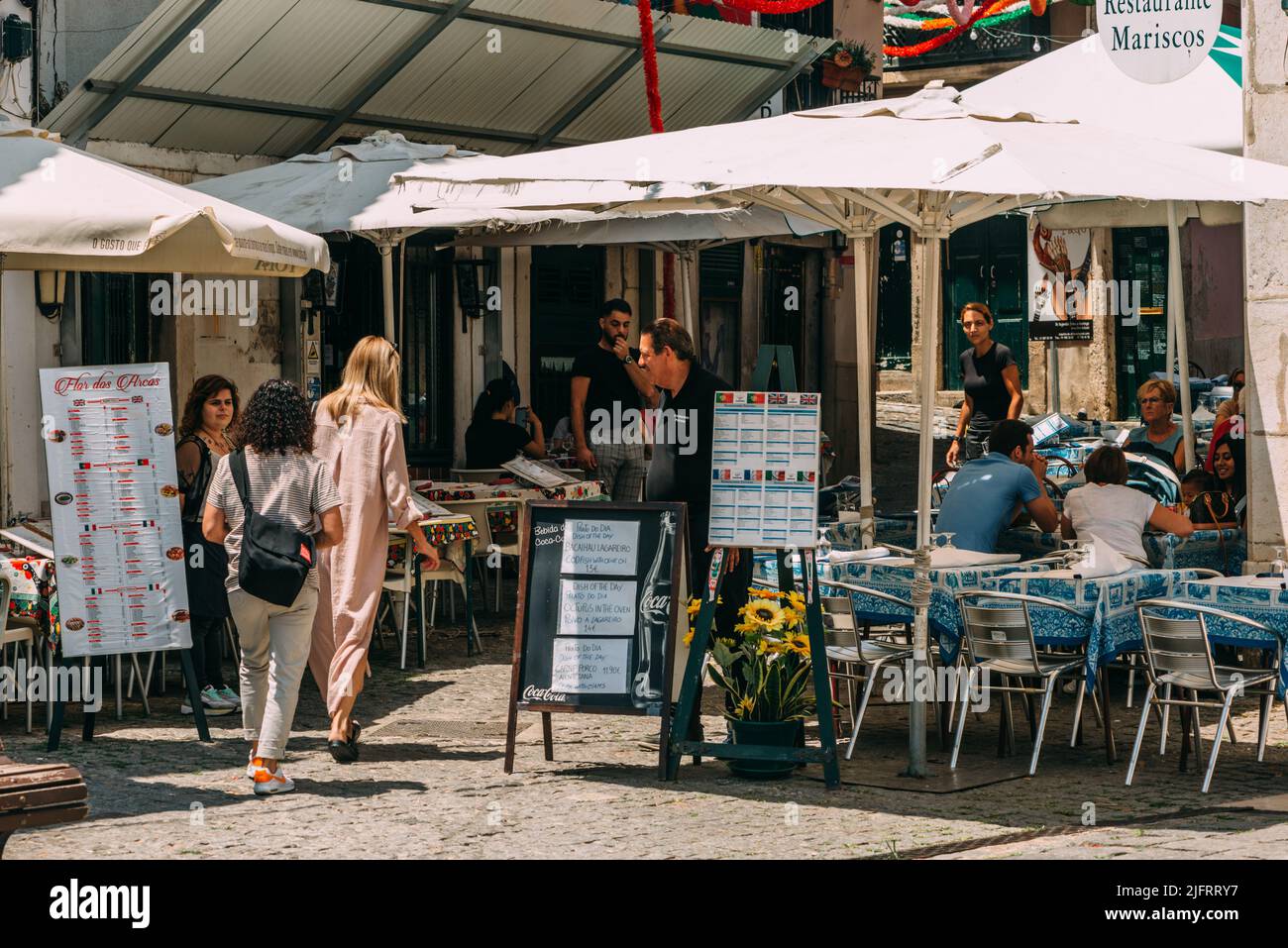 Touristen und Besucher kommen in die engen Gassen von Alfama Portugal, einem der ältesten Viertel Portugals und Heimat des Fado Stockfoto