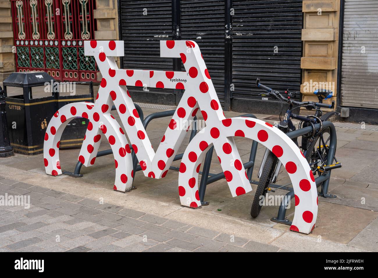 Weiß mit roten Punkten Fahrradträger in Form eines Fahrrads, der nachhaltiges Reisen in die Stadt Halifax, Großbritannien, ermöglicht. Stockfoto