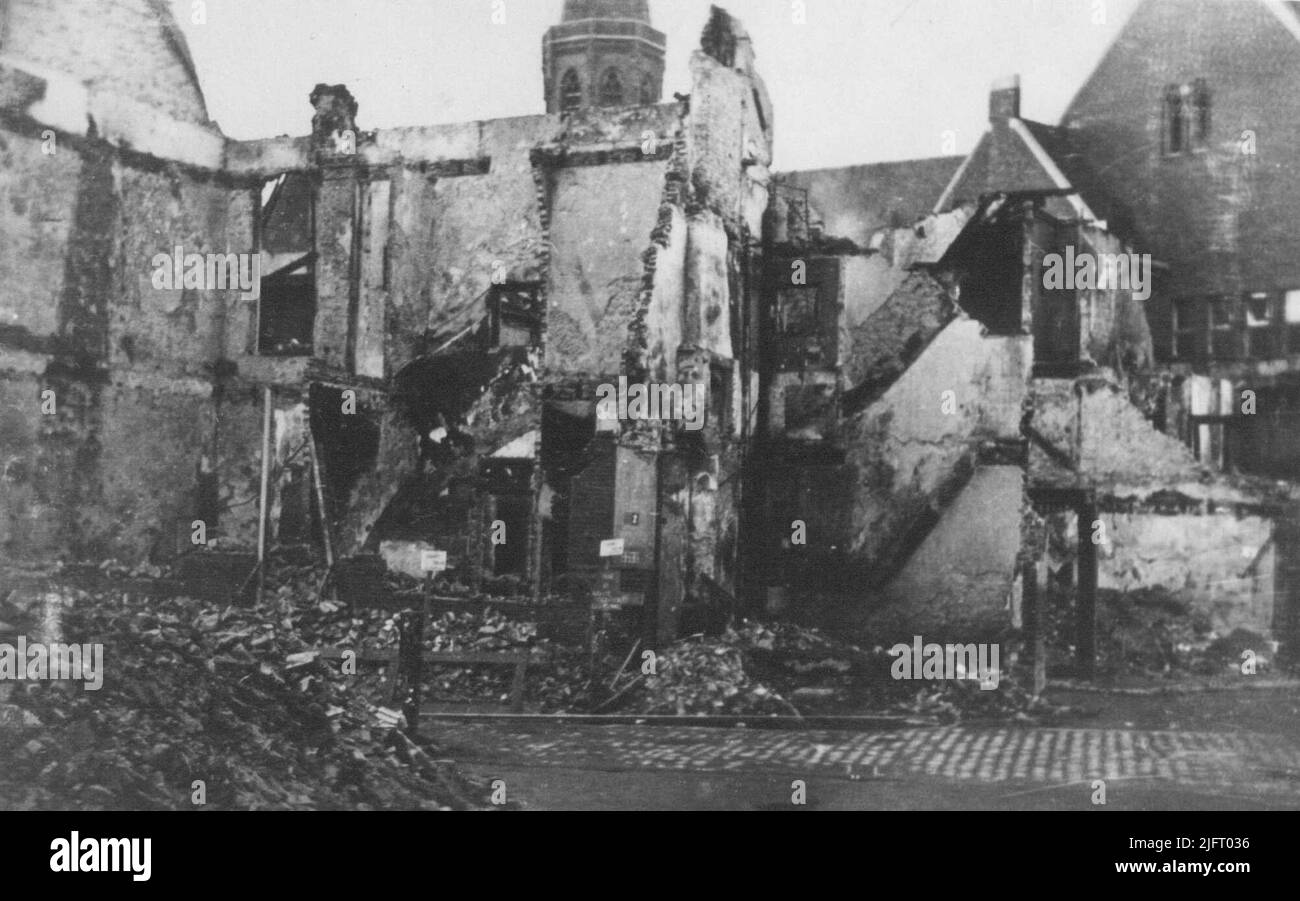 Bombardierte Gebäude an der Ecke mit der lange Nieuwstraat, rechts ein Teil der hinteren Fassade des Rathauses und im Hintergrund ein Teil des Turms der St. Dominicus Kirche (Broerstaatskerk). Stockfoto