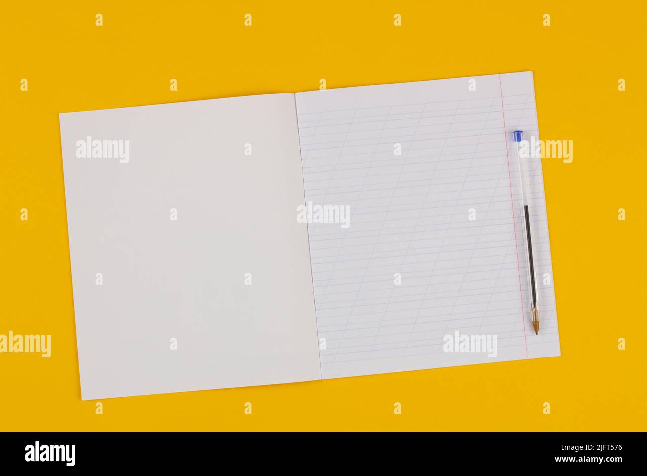 Schulnotizbuch auf gelbem Hintergrund mit Platz für Text und transparentem Stift. Zurück zur Schule. Leeres Blatt Papier mit schrägen Linien in exerci Stockfoto